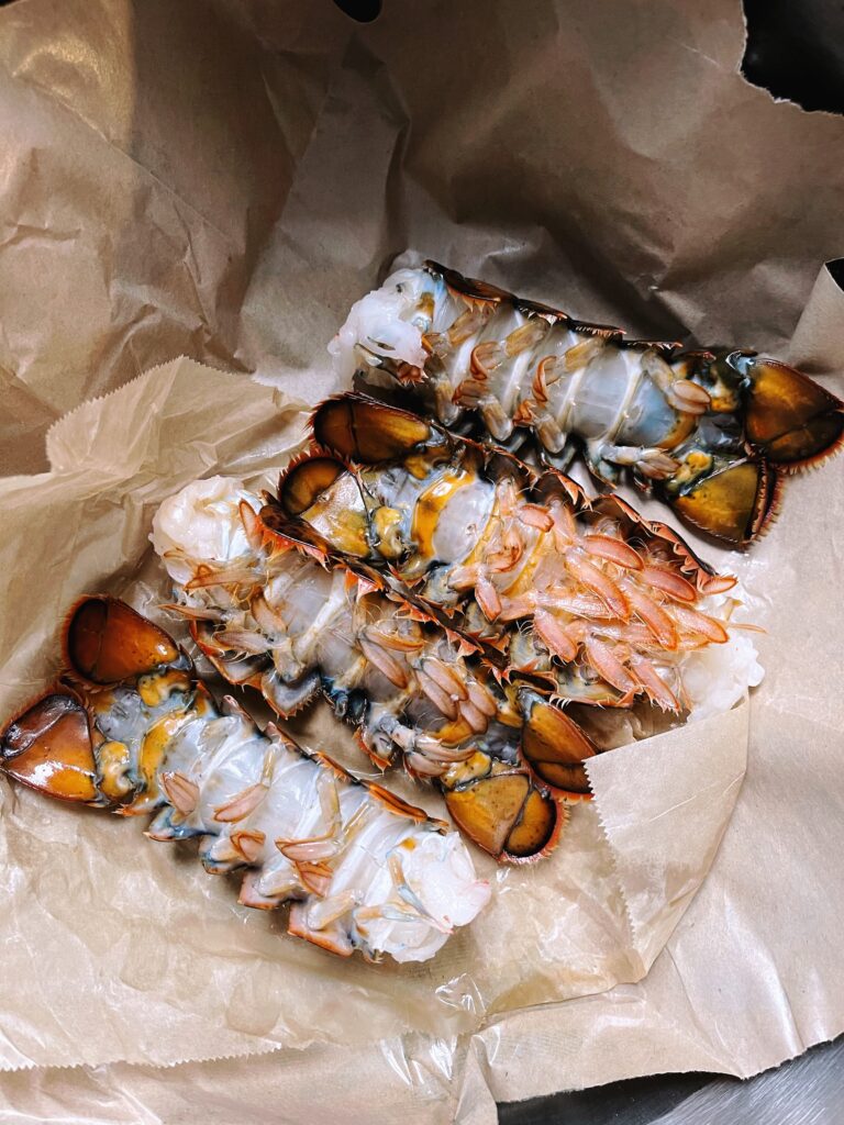 raw lobster tails on paper