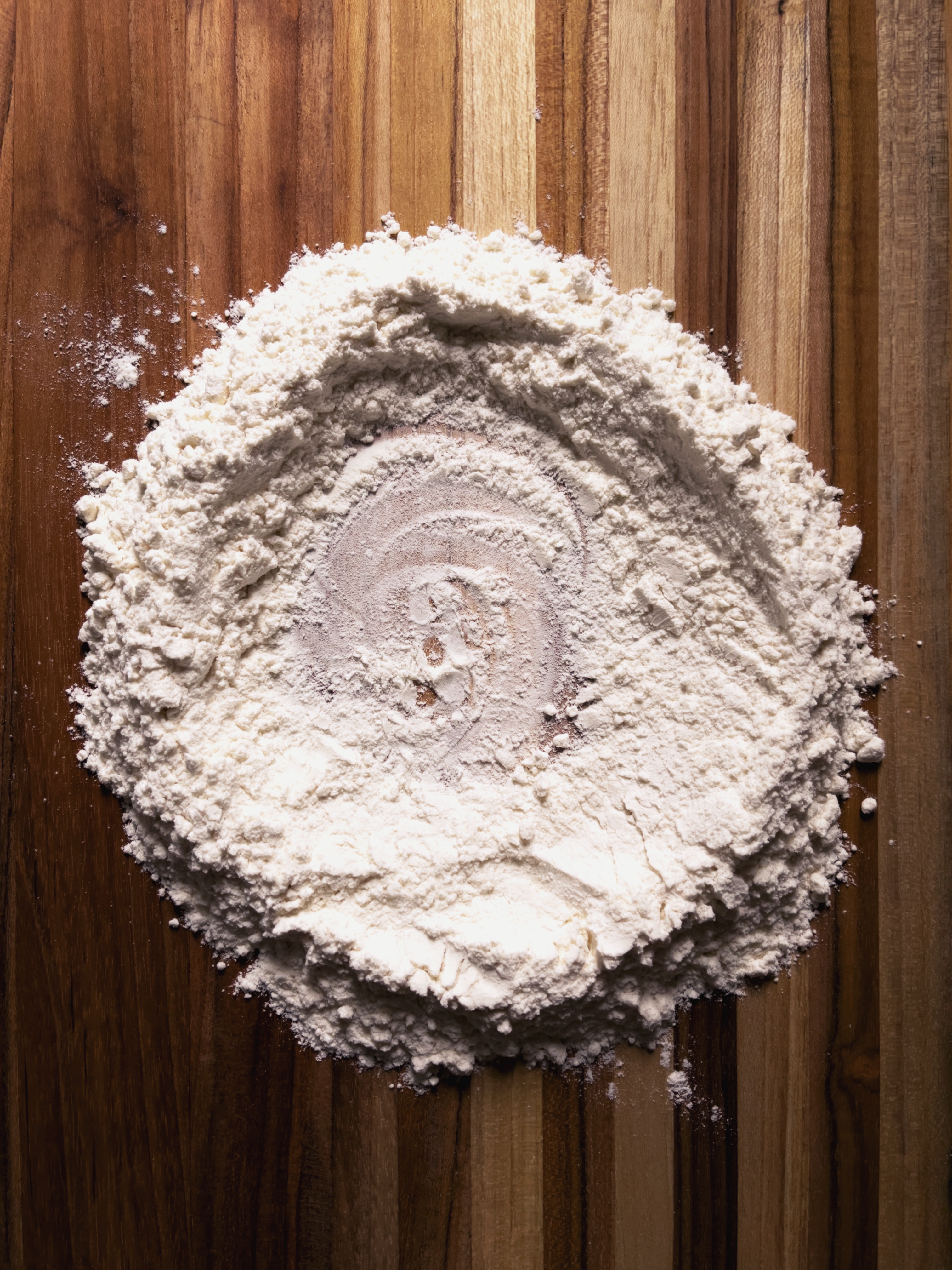 making pasta: flour in pile on wooden board