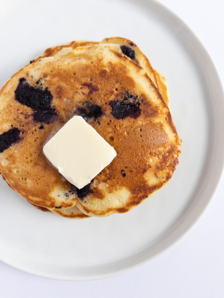 a plate of blueberry lemon poppyseed pancakes from above